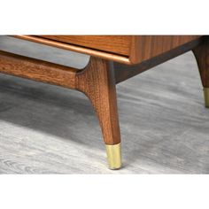 a wooden coffee table with brass legs