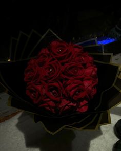 a bouquet of red roses sitting on top of a table