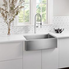 a stainless steel sink in a white kitchen