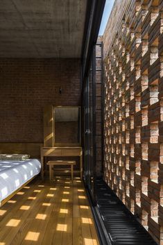 a bed sitting next to a wooden table on top of a hard wood covered floor