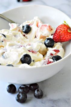 a white bowl filled with fruit and whipped cream