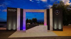 the entrance to mercedes benz is lit up with purple and blue lights at night time