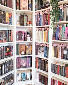 a book shelf filled with lots of books on top of white shelving units next to a wooden floor