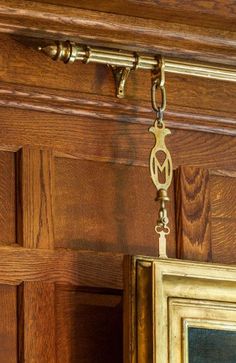 an antique key hangs from the side of a wooden door with a painting hanging on it