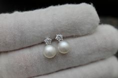 Material               : Genuine Natural Freshwater Pearl with Cubic Zirconia in 925 Sterling Silver Stud Post Quantity              : One Pair earring Pearl Color          :  Natural White Freshwater Pearl Shape                  :  Round Pearl (high luster) Pearl Size            :  7mm approx.  Earring Length   : 0.5 inch approx. *Due to the pearls are naturally grown, they won't be identical to each other* Lead Time & Shipping :  We ship your order in 1-2 business days (Mon-Fri).  If we offer FREE DOMESTIC shipping, package will be shipped via USPS First Class mail on orders shipping within the U.S. W H O L E S A L E    I N Q U I R Y :- Please convo us at anytime if you need to purchase in Wholesale Quantity and Custom Made Orders.  We will be very happy to assist you at our earliest con Brilliant Cut Sterling Silver Pearl Earrings For Wedding, Hypoallergenic White Gold Diamond Earrings For Wedding, Hypoallergenic White Diamond Earrings For Wedding, Classic White Bridal Earrings, Elegant Hypoallergenic Diamond Wedding Earrings, Elegant Hypoallergenic Diamond Earrings For Wedding, White Round Cut Earrings For Wedding, Wedding Pearl Earrings With Brilliant Cut, Wedding Round Cut Brilliant Pearl Earrings