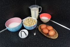 eggs, milk, and other ingredients are on the counter next to a measuring cup