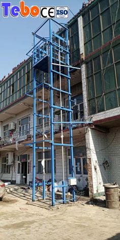 a tall blue tower sitting in front of a building with scaffolding on it