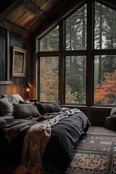 a bed sitting in front of a large window filled with lots of pillows and blankets