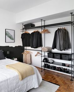 a bedroom with black and white clothes hanging on the wall next to a large bed