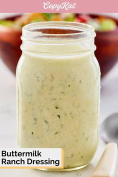 a jar filled with buttermik ranch dressing next to a spoon