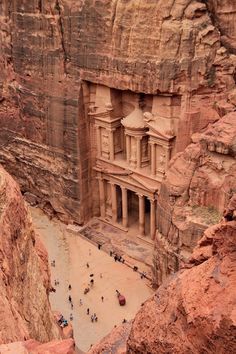 people are standing at the base of a cliff