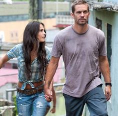 a man and woman holding hands while walking