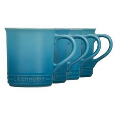 three blue mugs with the words le creuset on them are lined up