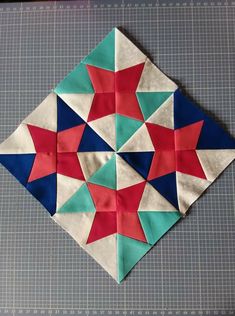 an origami piece is placed on the table to make a star quilt pattern