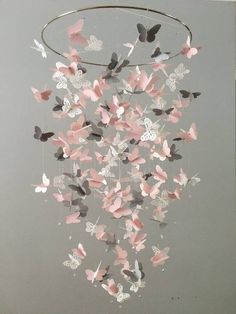 a mobile with pink and grey butterflies hanging from it's sides, in the shape of a circle