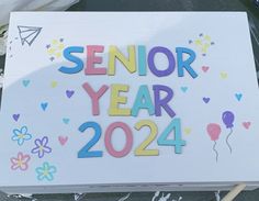 a white sign with the words senior year on it