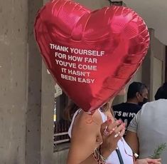 a woman holding a red heart shaped balloon with the words thank yourself for how far you've come it hasn't been easy