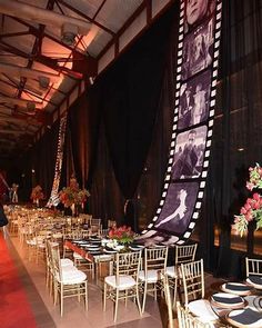 an indoor event venue with tables and chairs set up in front of a black curtain