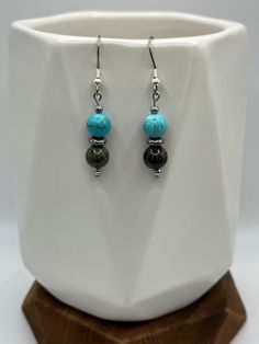 These earrings combine the vibrant energy of turquoise howlite with the unique, earthy tones of dragon blood jasper, evoking a sense of natural beauty and mystique. As each piece is handmade, there may be slight variations in each.  Listing includes hypoallergenic ear wires. Should you prefer .925 Sterling Silver, please message us so we can create a custom item for you.  These pair beautifully with our Turquoise Serpent Beaded Bracelet!  Caring for your jewelry means you will enjoy its beauty f Adjustable Jasper Jewelry In Turquoise, Turquoise Jasper Round Bead Jewelry, Turquoise Gemstone Beads Earrings As Gift, Spiritual Turquoise Earrings With Natural Stones, Turquoise Jasper For Jewelry Making, Turquoise Jasper Jewelry For Jewelry Making, Turquoise Jasper Jewelry With Natural Stones, Turquoise Jade Earrings For Gift, Turquoise Jade Earrings With Natural Stones