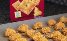 chicken nuggets on a baking sheet next to a box of crackers