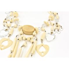 From a Miami socialite's estate, this necklace and matching earrings  are truly a statement piece.  Made in the 1980's, the necklace has carved and smooth bone pieces with gold tone bead accents as well as facetted crystal beads and hearts.    The necklace has sterling silver lobster clasp.  The earrings are 2.78" by .56" wide.  They have post backs so you must have pierced ears.  The necklace is 15" long and 7.25" wide at the bib area and .62" depth. Elegant Handmade Bone-colored Jewelry, Unique Carved Bone Jewelry, Unique Bone-colored Carved Jewelry, Carved Bone, Bone Carving, Dangling Earrings, Bib Necklace, Bohemian Chic, Pierced Ears