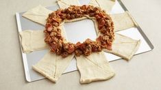 a white plate topped with crackers covered in toppings on top of a table