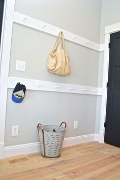 there is a basket on the floor and a bag hanging from the wall above it