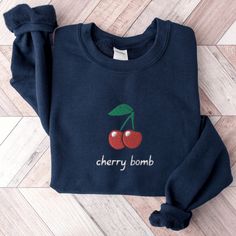 Cherry Bomb Sweatshirt, Cute Cherries Sweater, Embroidered Cherry Shirt, Embroidered Fruit Sweater, Cute Crewneck Sweater, Cute Cherry Shirt This embroidered cherry bomb crewneck sweatshirt is everything.  Please let me know if you would like extended sizing (3X-5X), I have certain color and size options available! ✨ 50% cotton, 50% polyester ✨ Pre-shrunk ✨ Classic fit Care: Machine wash: warm (max 40C or 105F) Tumble dry: low Do not iron directly on the print REFUNDS AND EXCHANGES All items are made to order using multiple suppliers to ensure quick worldwide shipping. For this reason we are unable to accept returns/exchanges unless there's a defect in the item you've received. Thank you so much for shopping! Please send me a message if you have any questions, concerns or custom requests. Embroidered Cotton Crew Top, Winter Embroidered Multicolor Sweatshirt, Fall Multicolor Embroidered Logo Tops, Multicolor Embroidered Logo Tops For Fall, Fall Tops With Multicolor Embroidery And Logo, Winter Embroidered Cotton Tops, Winter Multicolor Embroidered Cotton Sweatshirt, Winter Floral Embroidery Cotton Top, Winter Cotton Sweatshirt With Multicolor Embroidery