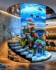 a fish tank in the middle of a spiral staircase with corals and other marine life