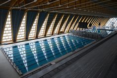 an indoor swimming pool in the middle of a building with large windows on each side