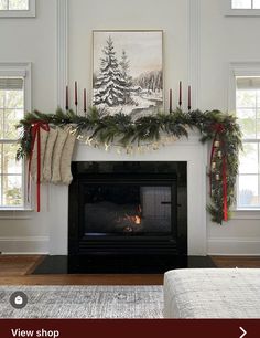 a fireplace decorated for christmas with stockings and garland on it's mantel above the fire