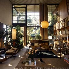 a living room filled with lots of furniture and bookshelves next to a window