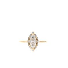 a yellow gold ring with an oval cut diamond surrounded by small white and brown diamonds