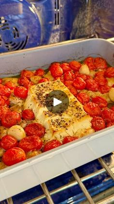 a casserole dish with tomatoes and fish in it