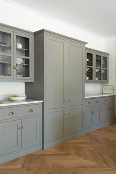 a kitchen with gray cabinets and wood floors