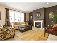 a living room filled with furniture and a fire place in the middle of a room