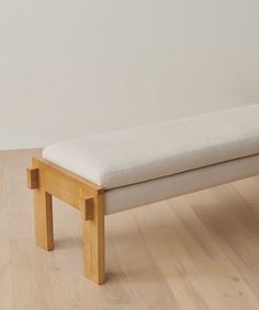 a wooden bench sitting on top of a hard wood floor