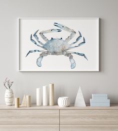 a blue crab sitting on top of a wooden dresser