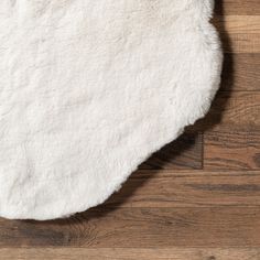 a white rug is laying on top of a wooden floor and it looks like something out of space