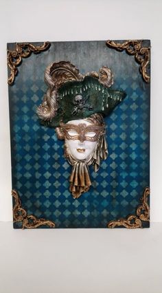 a blue and gold wall hanging with a woman's face wearing a green hat