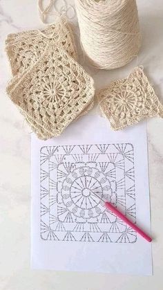 crocheted doily, yarn and scissors on a white table with a piece of paper