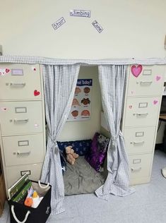 an office cubicle with lots of drawers and curtains on the walls, including a bed