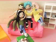 three dolls sitting on top of a pink couch