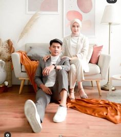 two people sitting on a couch in a room