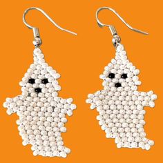 white beaded ghost earrings on an orange background