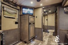 the interior of a motor home with wood flooring and walls, including a television