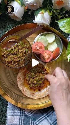 a person holding a plate with food on it and dipping sauce in the other hand