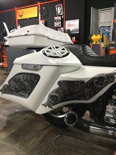 a white motorcycle parked in a garage next to a boat on the back of it