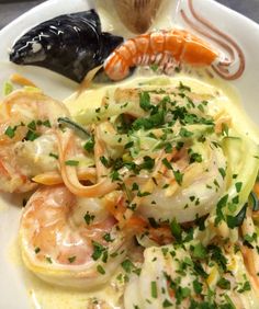 a white plate topped with shrimp and pasta