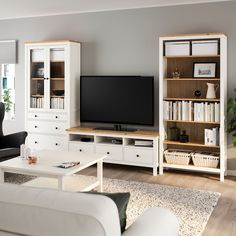 a living room filled with furniture and a flat screen tv on top of a wooden entertainment center